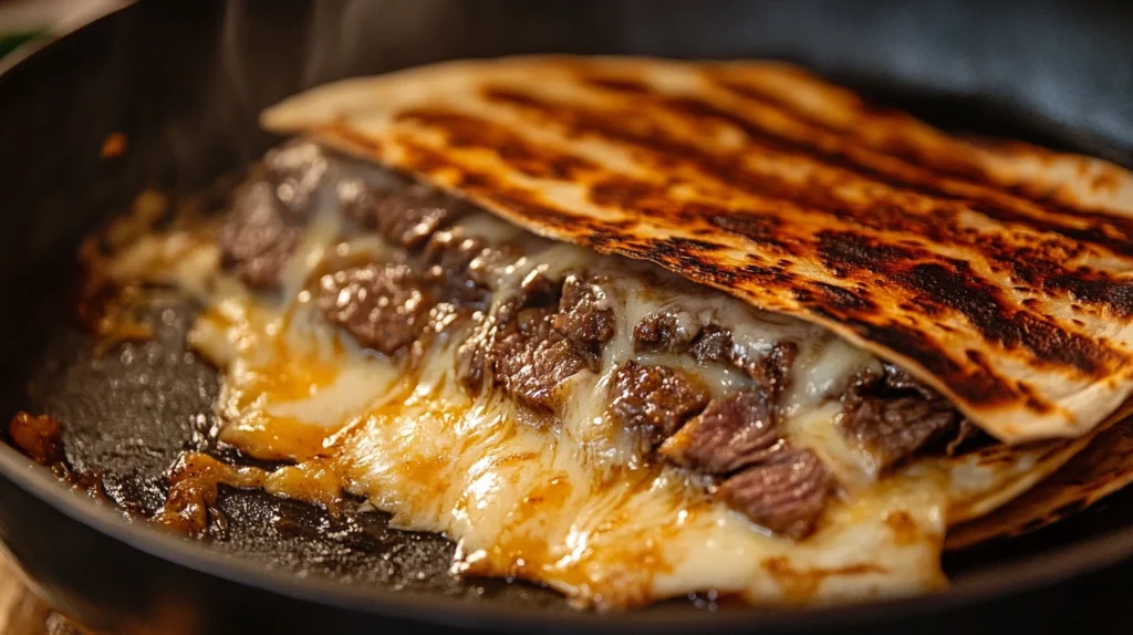 A skillet with a folded steak quesadilla cooking to golden perfection.